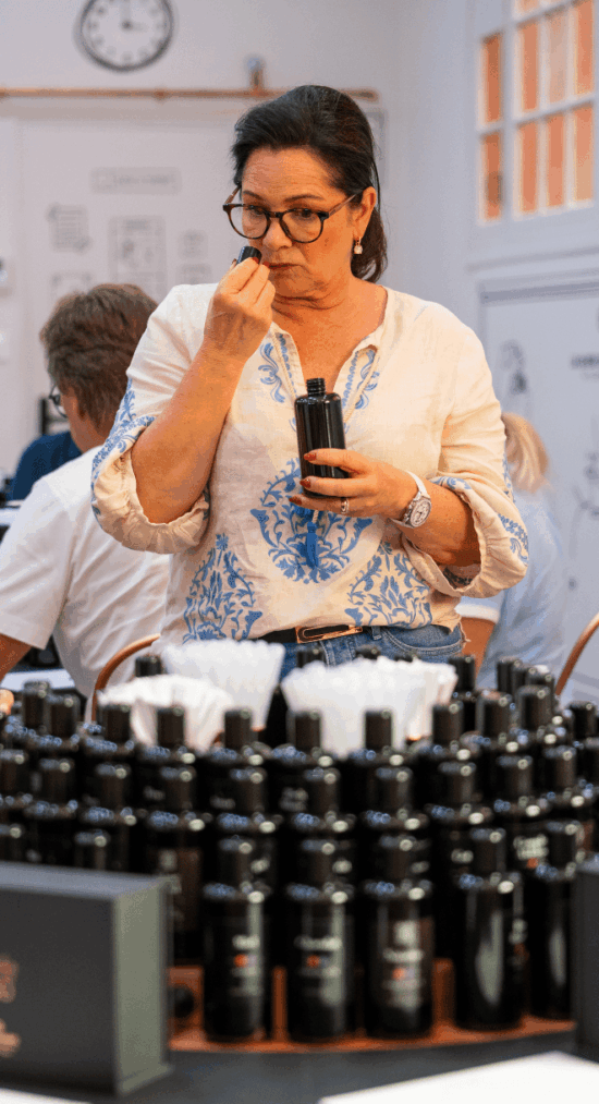 Frau beim Testen von Düften während eines Workshops auf einer Sportwagen Erlebnisreise.