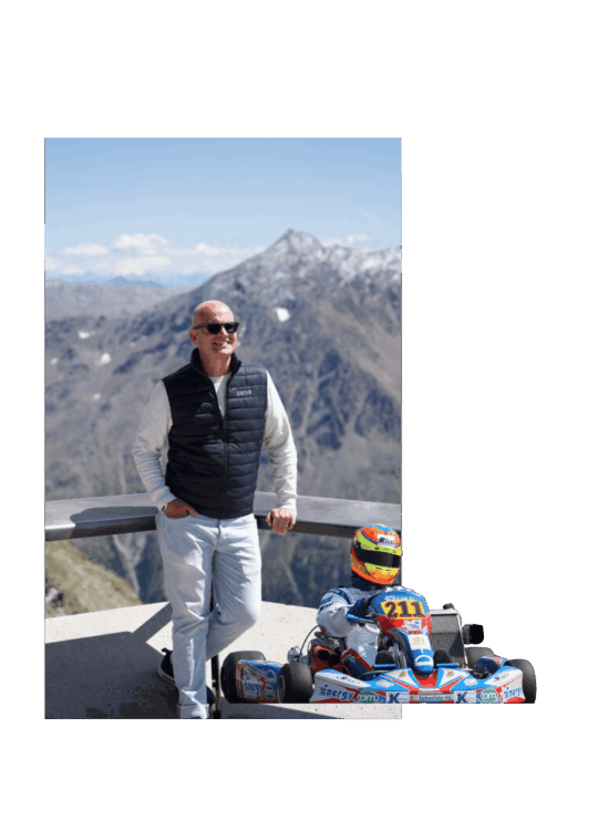Sportwagen Erlebnisreisen: Ernst Behrens posiert auf einer Aussichtsplattform in den Hochalpen. Als Montage ist ein altes Foto von ihm als Kartfahrer mit dabei.