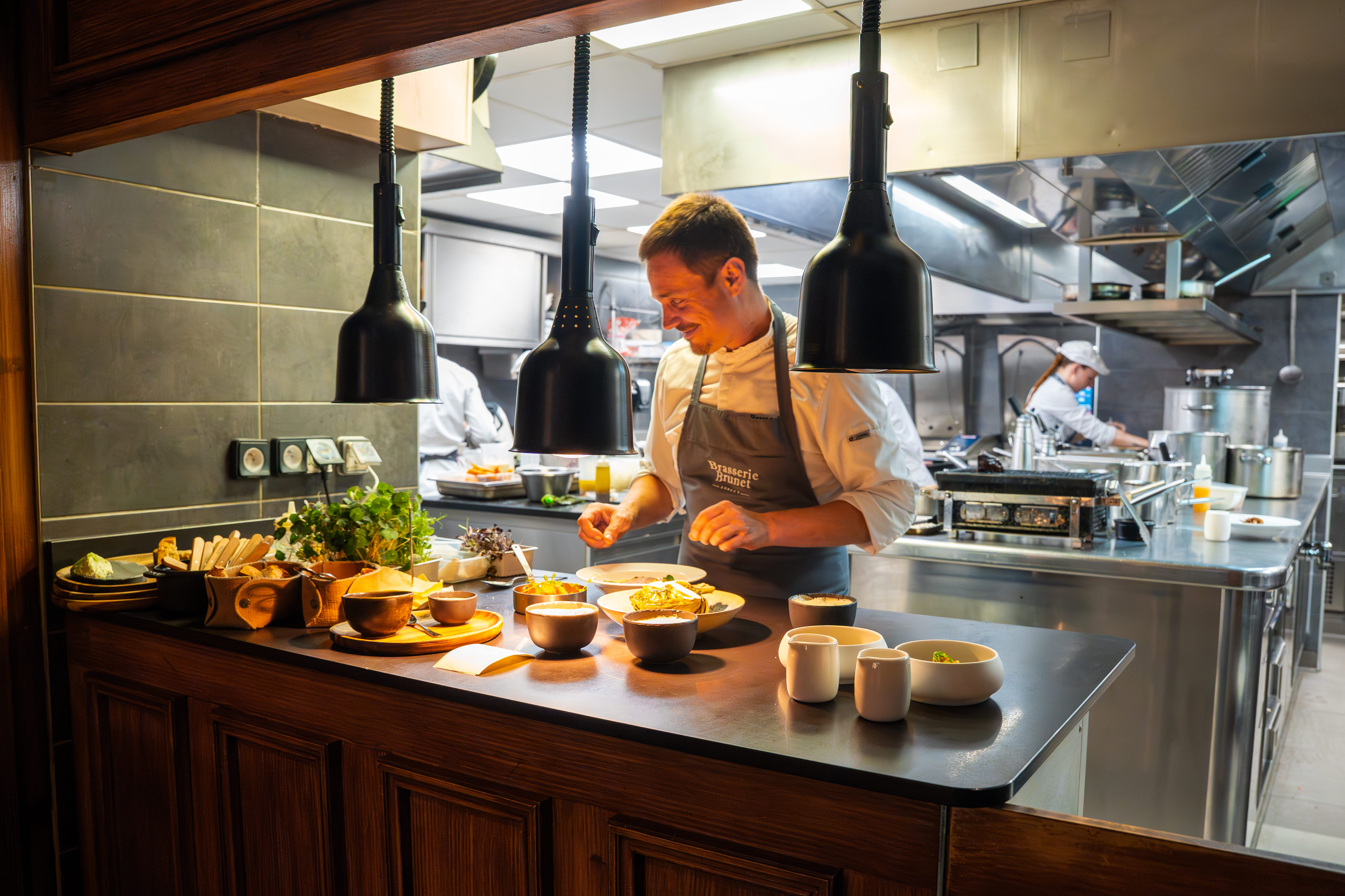 Koch beim Anrichten exklusiver Speisen in der Brasserie Brunet während einer Sportwagen Erlebnisreise.