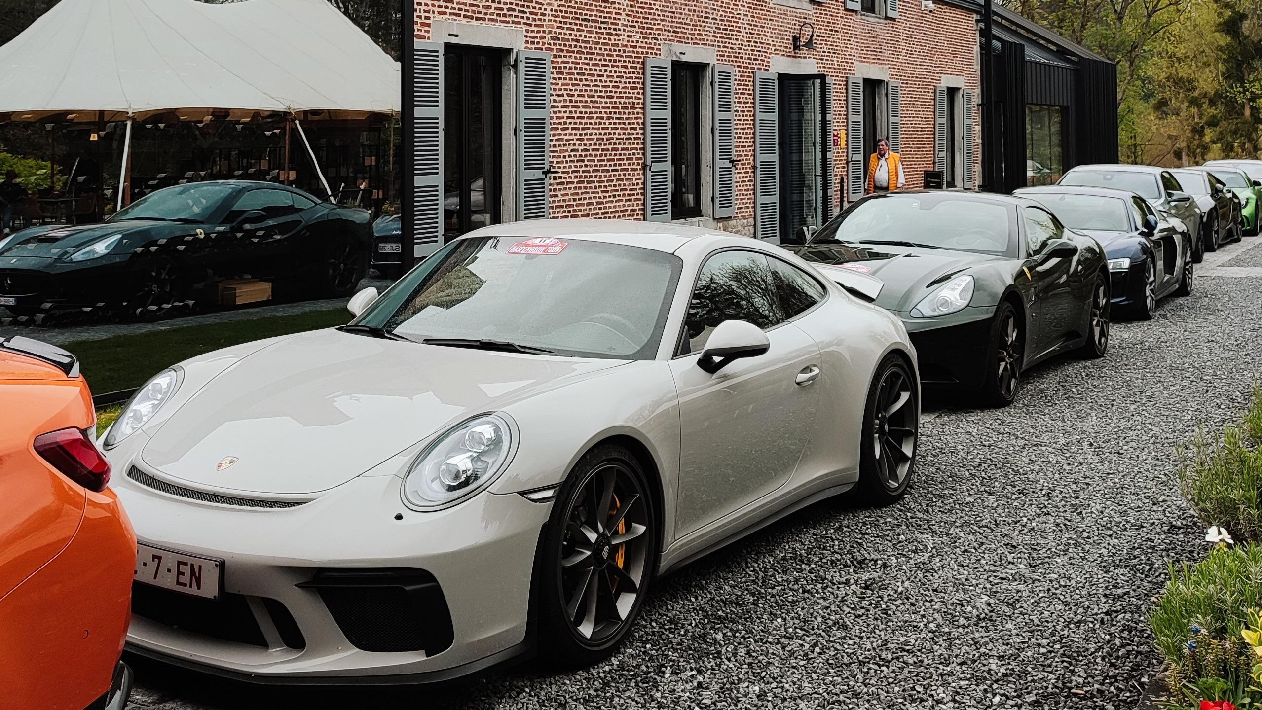 Ardennen Tour: Konvoi von Luxus-Sportwagen (Porsche GT3, Ferrari) vor dem Hotel.