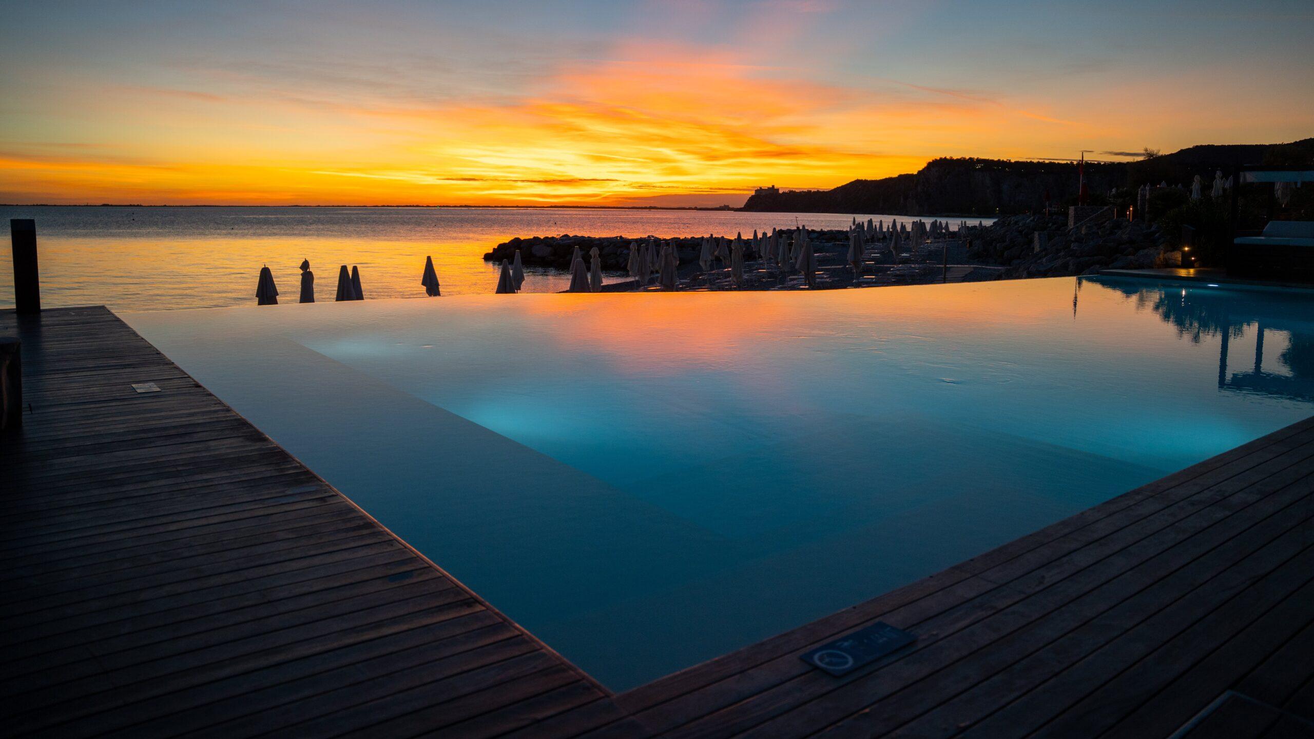 Infinity-Pool spiegelt malerischen Sonnenuntergang an der französischen Riviera wider.
