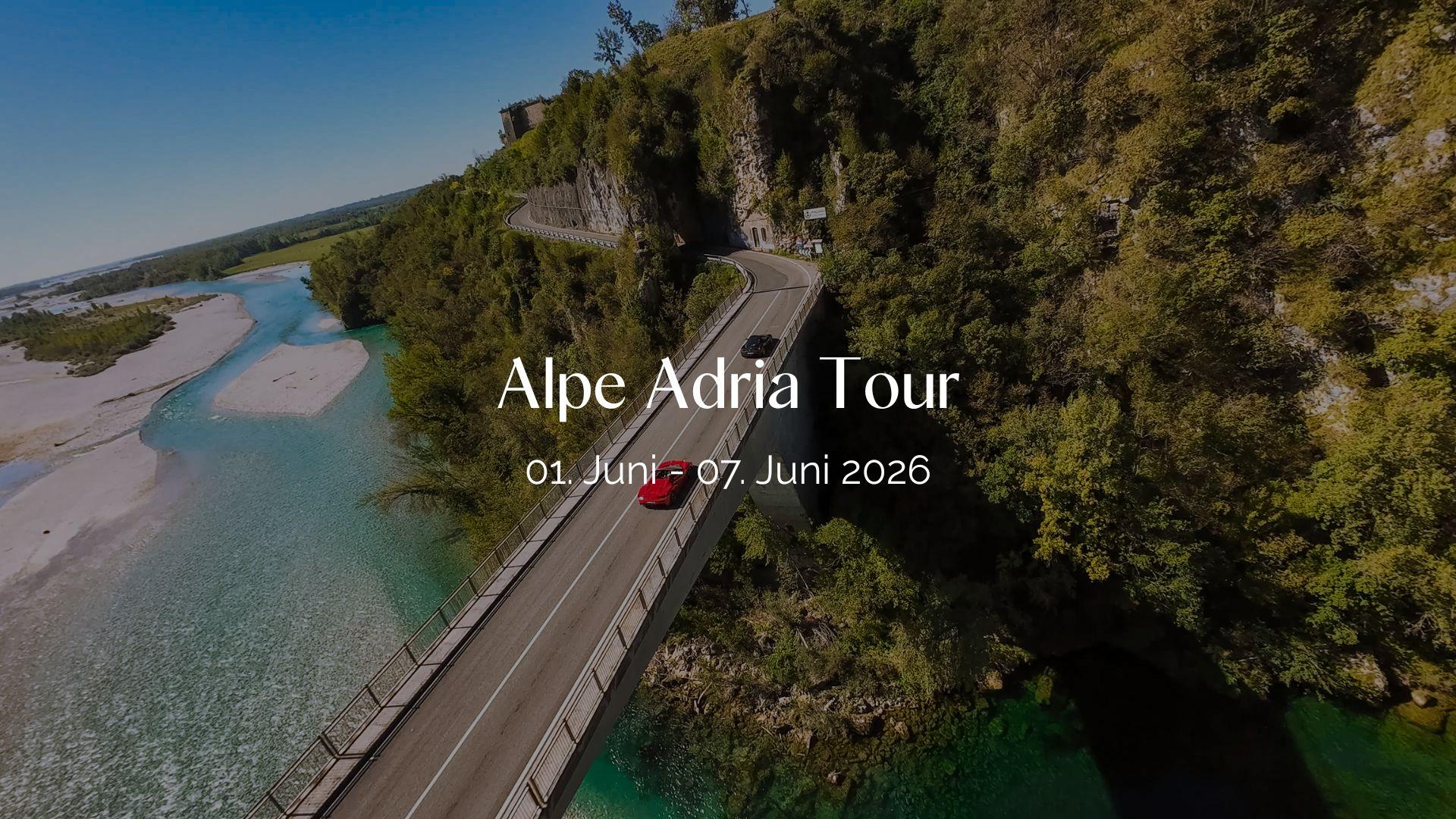 Header Bild der Alpe Adria Tour: Roter Sportwagen auf alpiner Straße über türkisblauem Fluss.