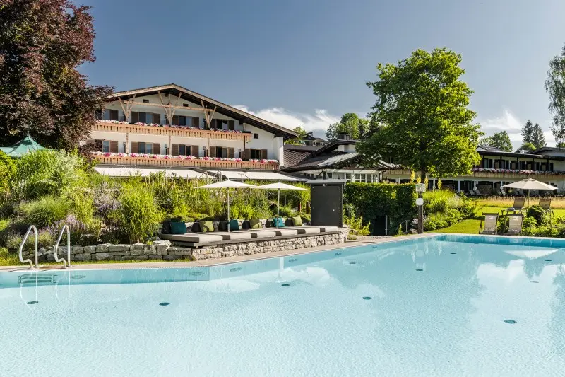 Luxushotel in den Alpen mit Außenpool und üppiger Landschaft.