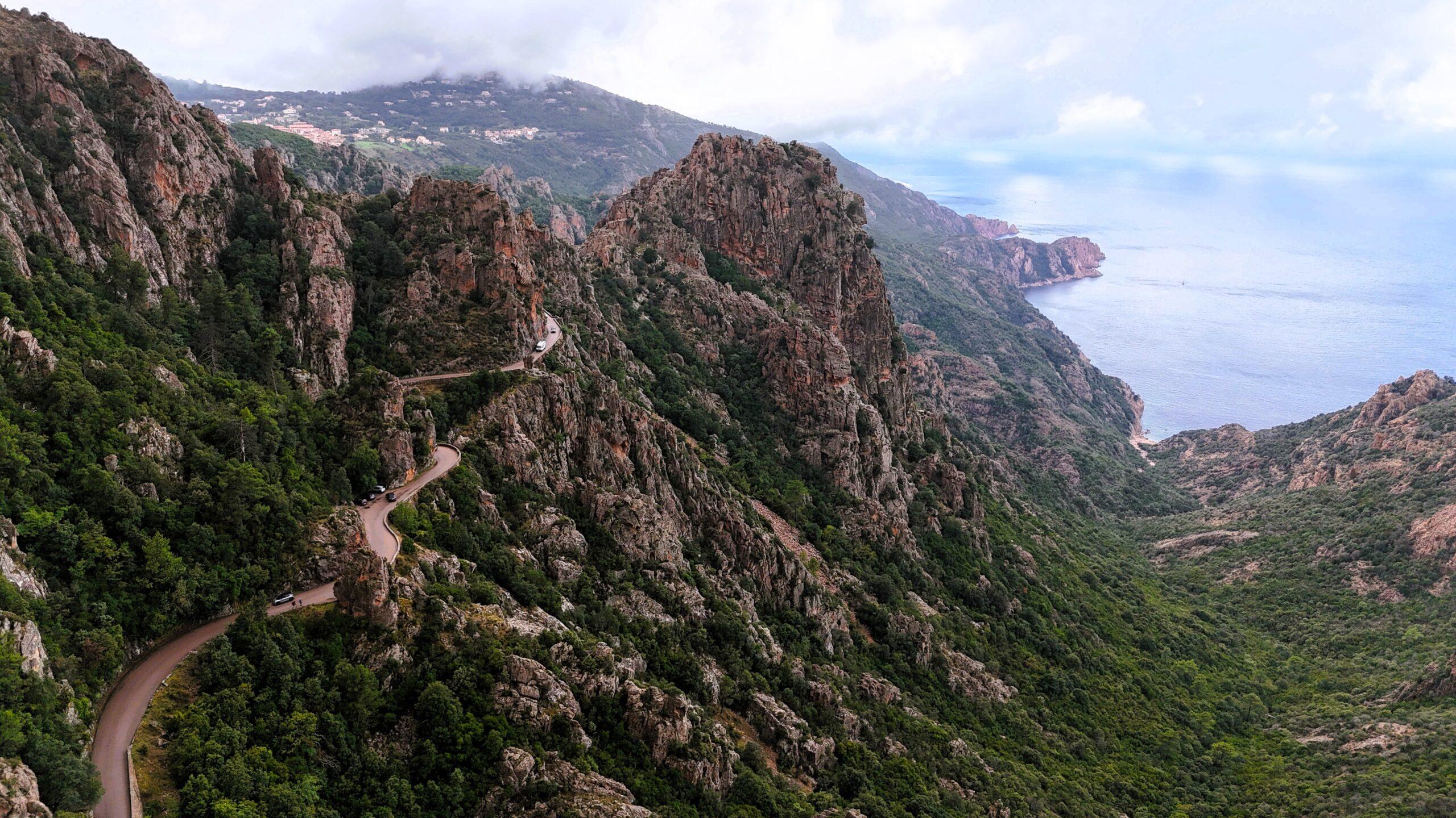 Serpentinenstraße durch beeindruckende Berglandschaft mit Blick auf das Meer.