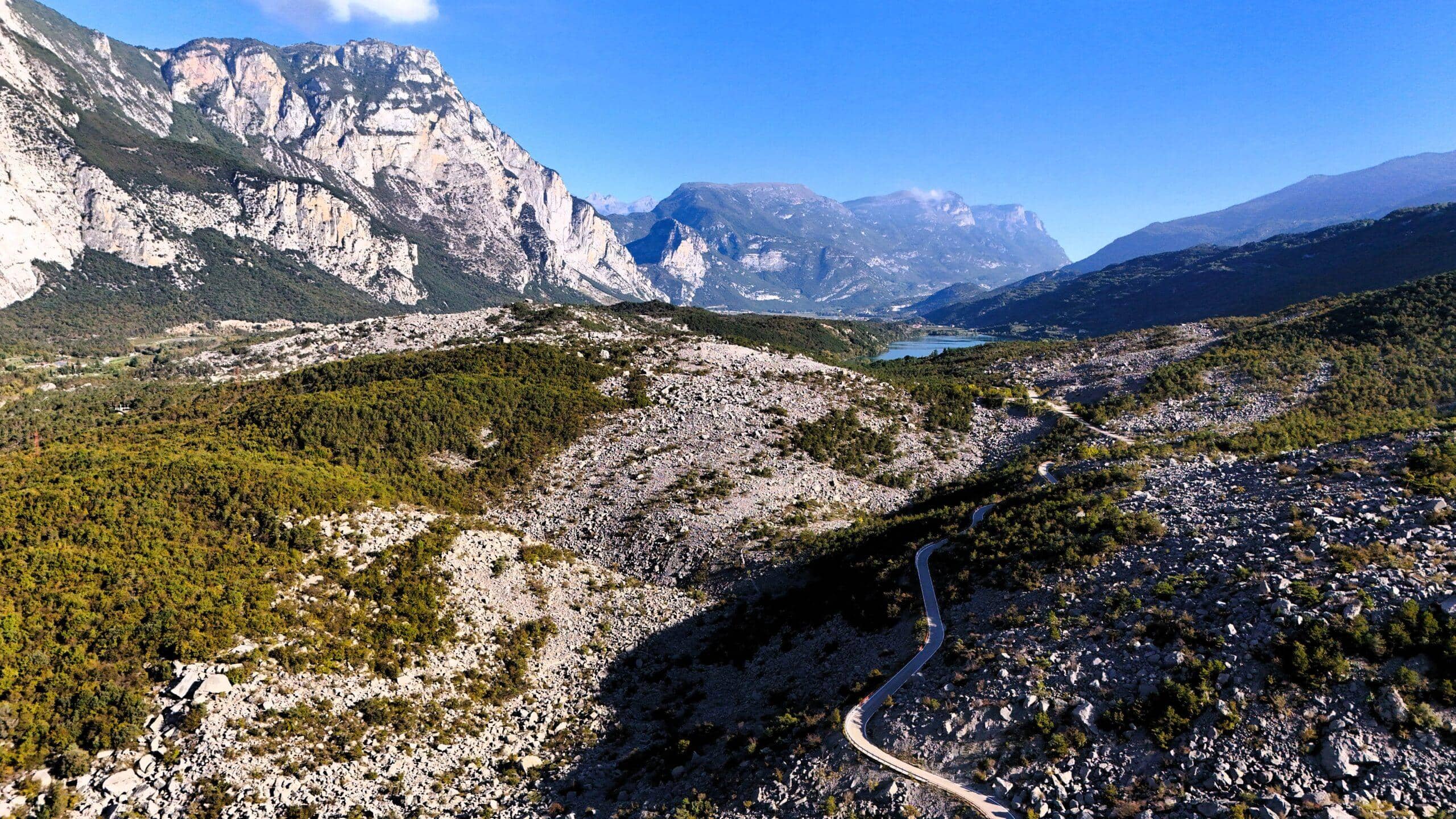 Atemberaubende Berglandschaft mit kurvenreicher Straße und klaren Seen in der Ferne. Ideal für Fahrerabenteuer.