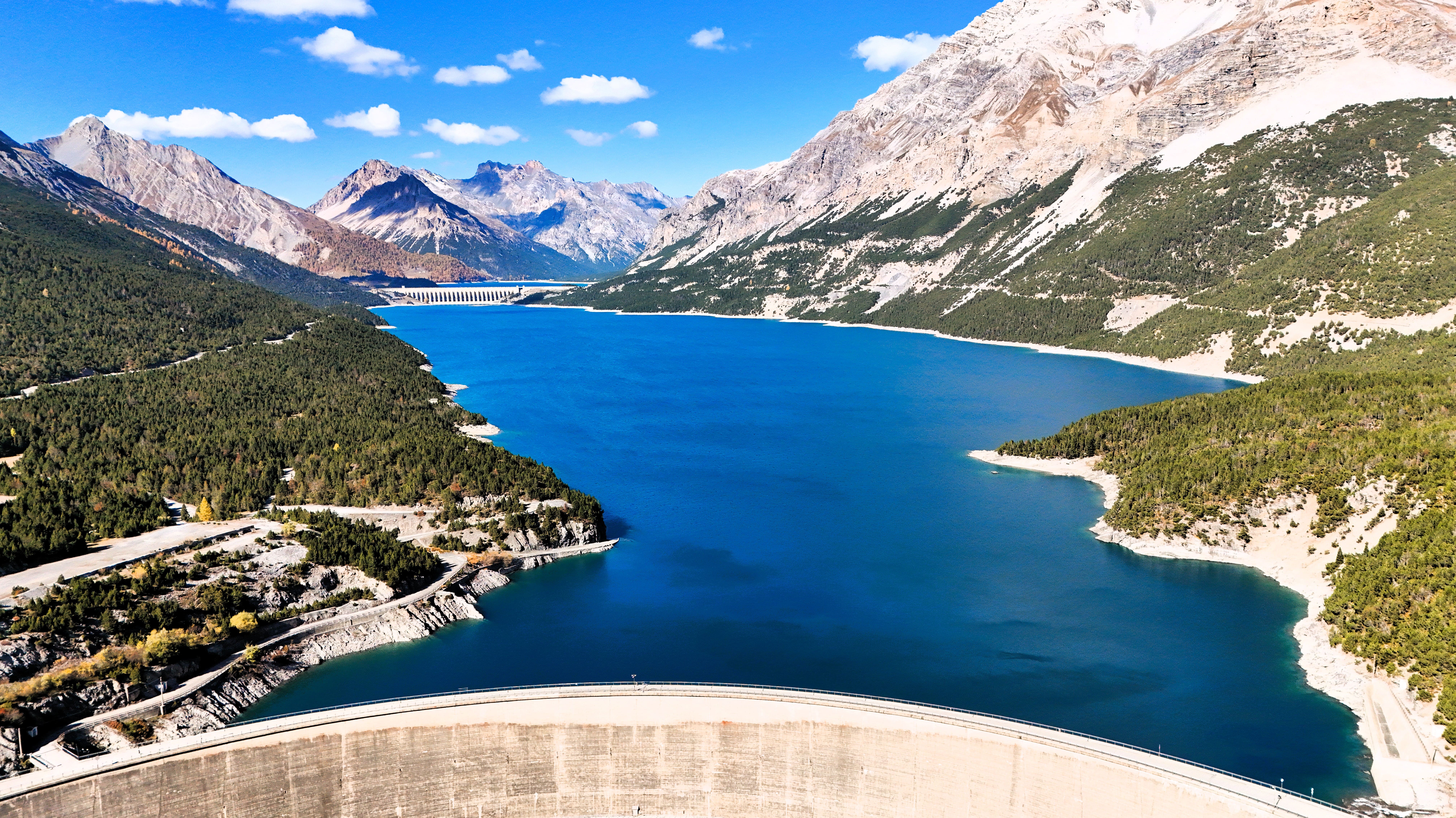 Weitblick auf den smaragdgrünen Stausee inmitten der malerischen Alpenlandschaft.