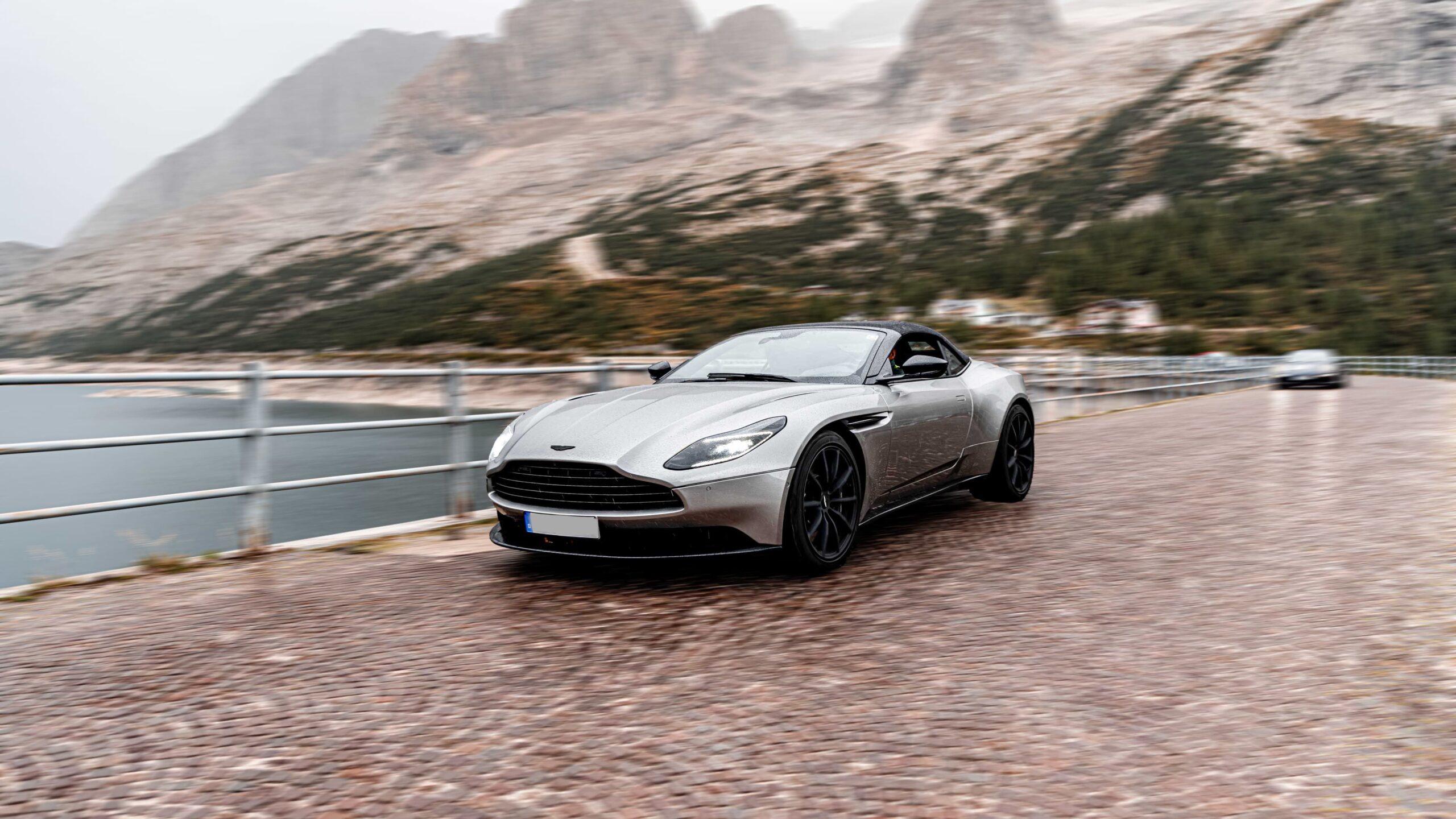 Sportwagen fährt auf malerischer Bergstraße in den Dolomiten entlang.