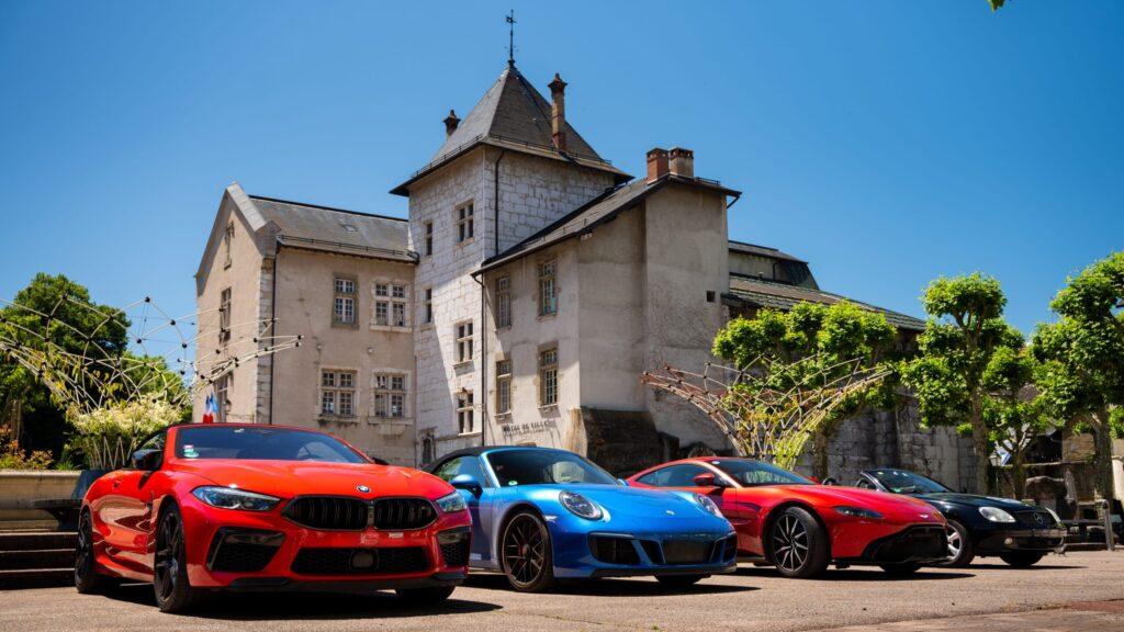 Luxuriöse Sportwagen vor einem historischen Gebäude im sonnigen Alpenumfeld. Perfekte Kulisse für unvergessliche Abenteuer.