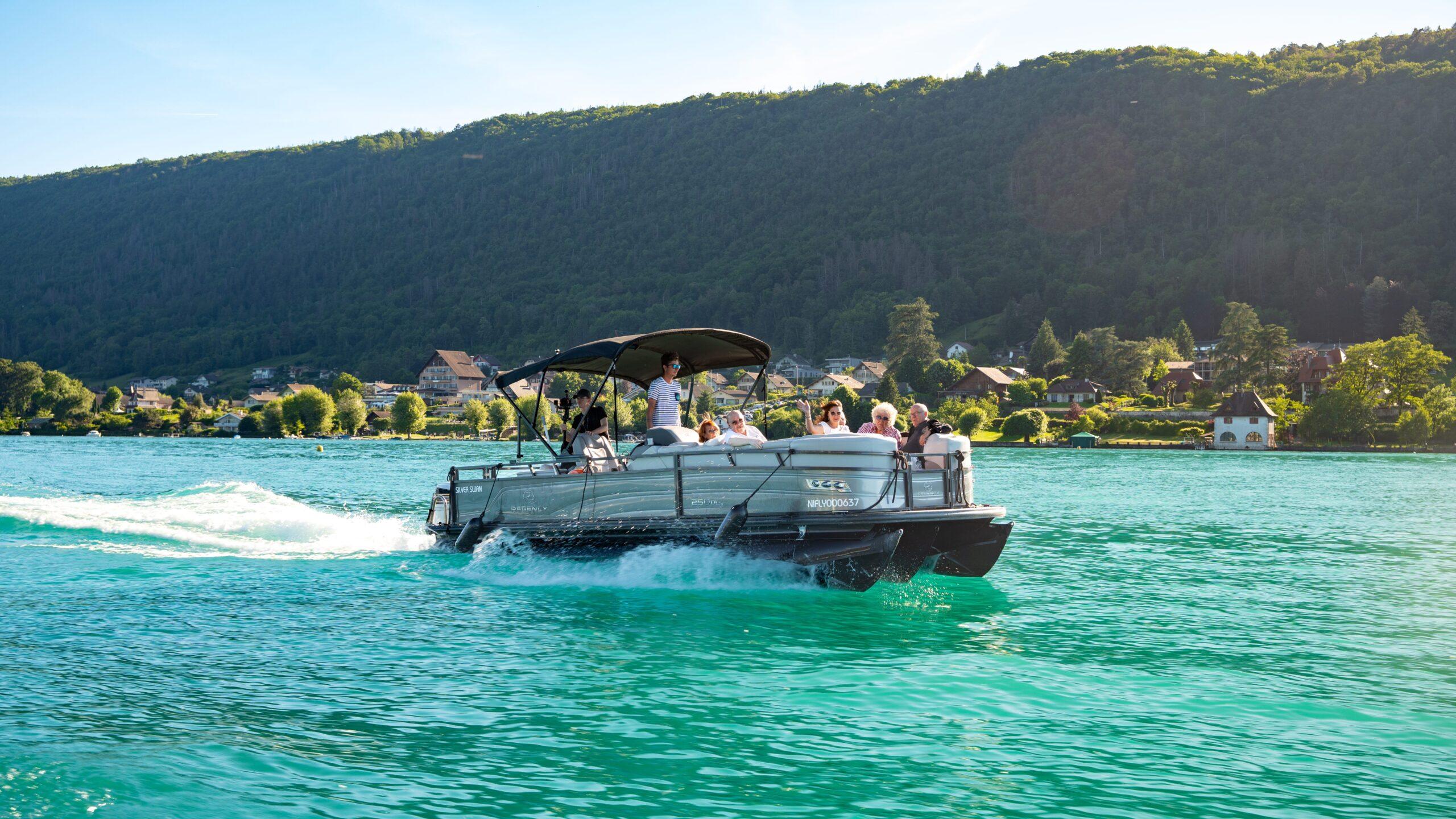 Eine Gruppe genießt eine luxuriöse Bootsfahrt auf einem malerischen Alpensee.