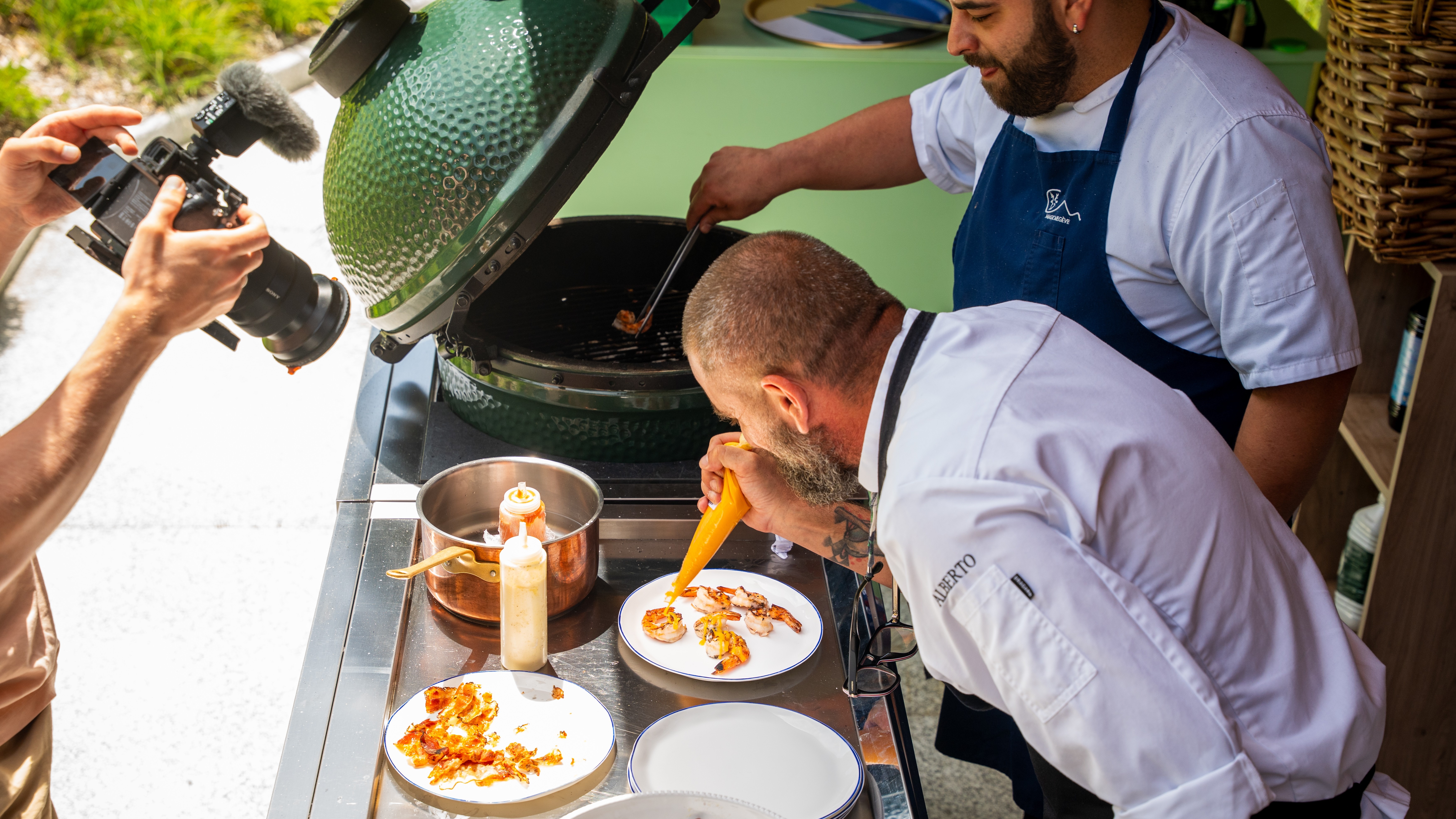 Köche bereiten exklusive Gourmet-Speisen zu, während ein Videograf die Szene für die Tour festhält.