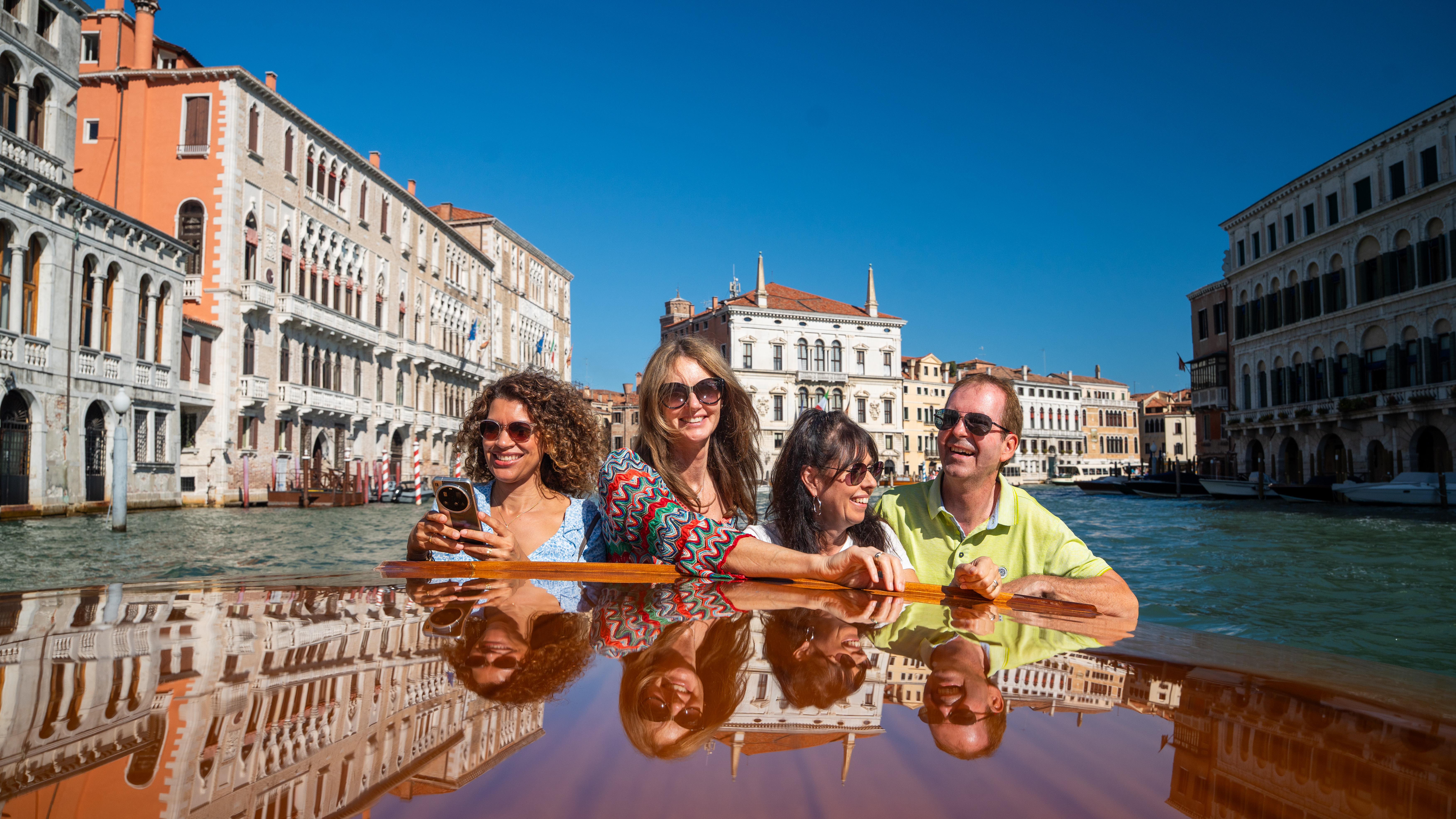 Gruppe von Touristen genießt eine Bootsfahrt entlang der Kanäle in Venedig.