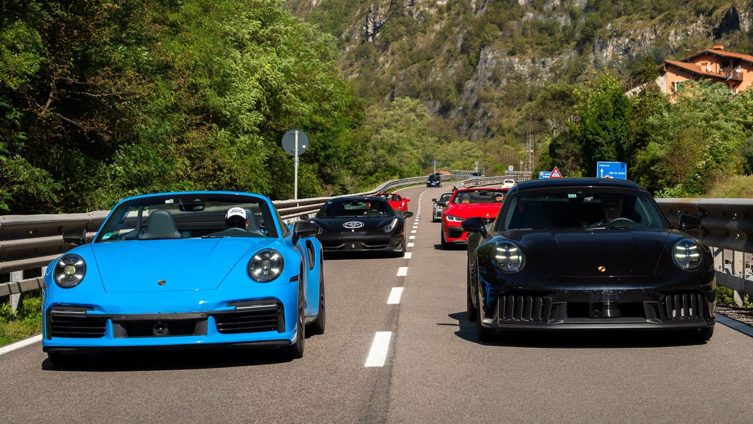 Sportwagen Konvoi: Schwarzer und blauer Porsche führen die Gruppe auf der Alpe Adria Tour.