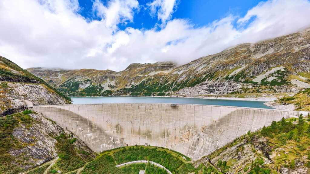 Großer Staudamm umgeben von atemberaubenden Berglandschaften in den Alpen.