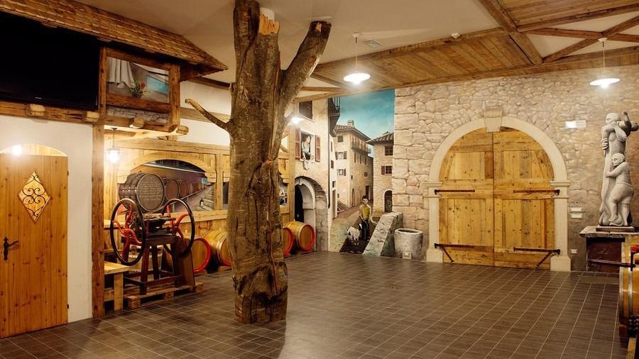 Gemütliche Weinkeller-Atmosphäre mit rustikalen Holzfässern und lebendigem Wandbild.