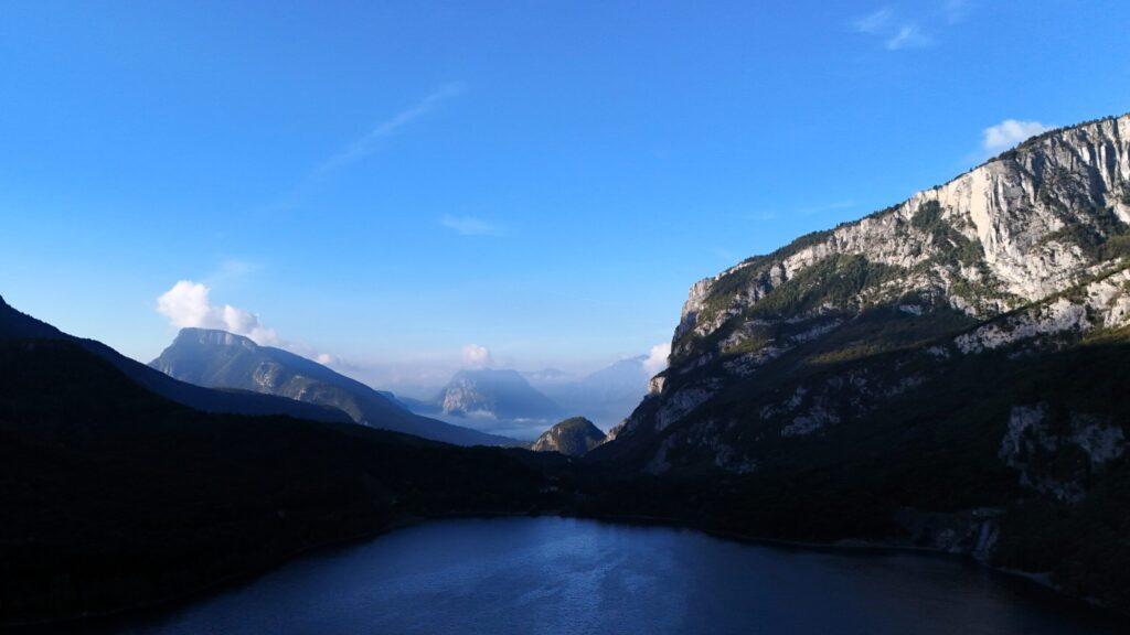 Blick auf beeindruckende Berglandschaft und See in den Alpen bei blauem Himmel.
