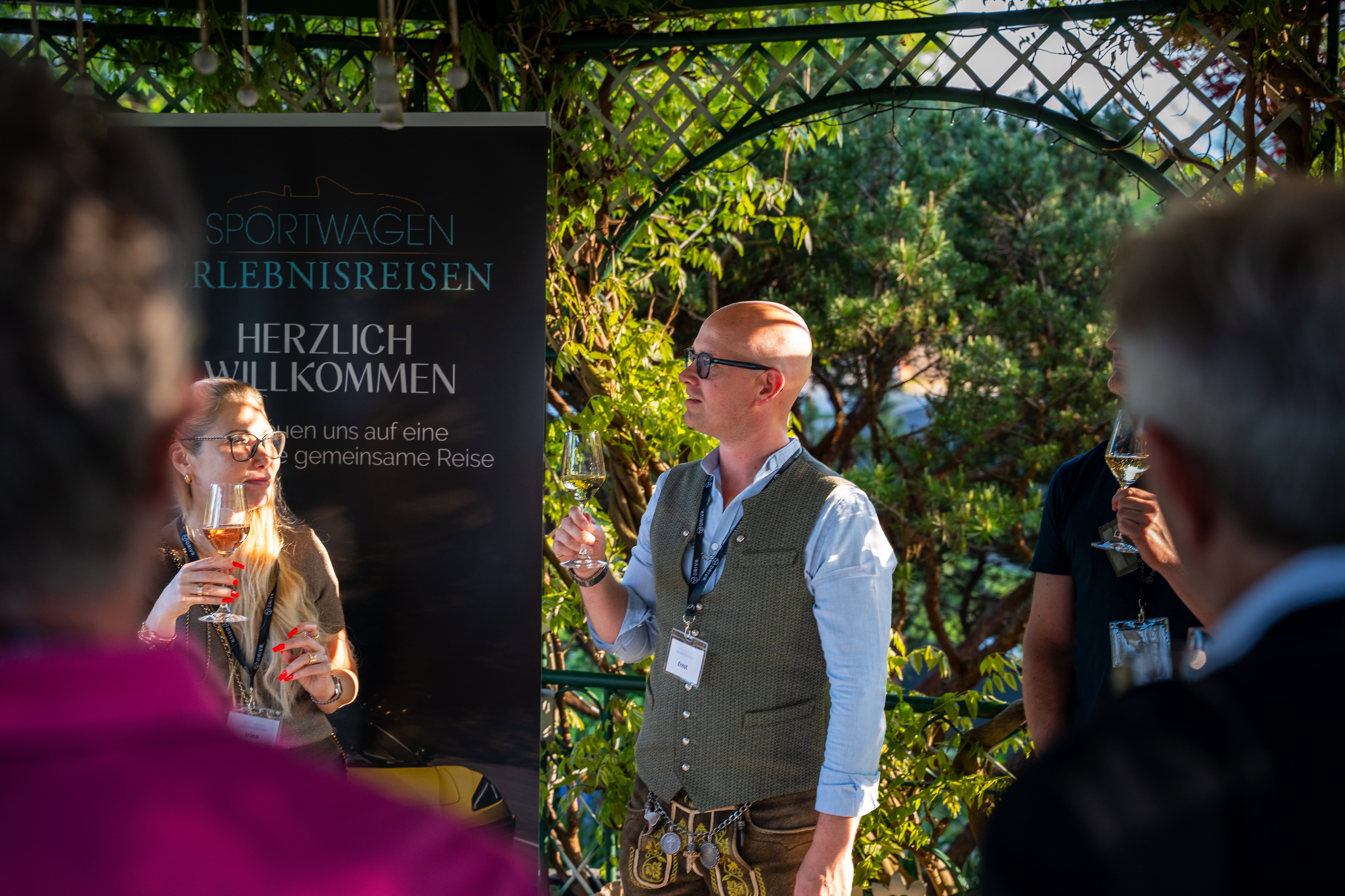 Leute genießen eine Begrüßungsveranstaltung während einer Sportwagenreise in Europa.