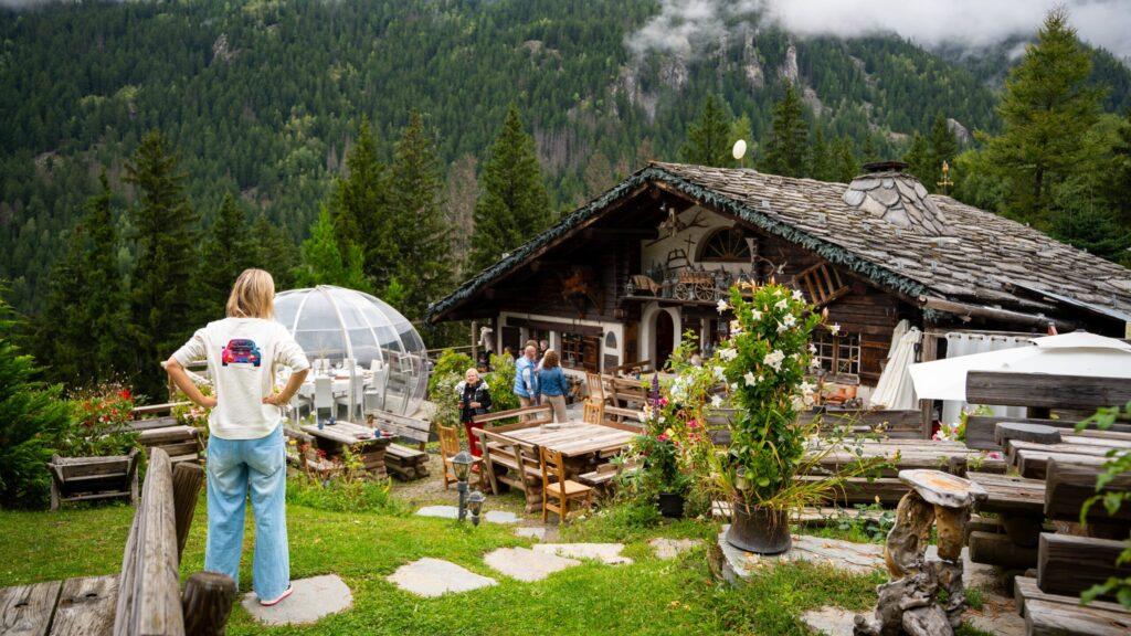 Gemütliche Berghütte in den Alpen, umgeben von malerischer Natur und Menschen.