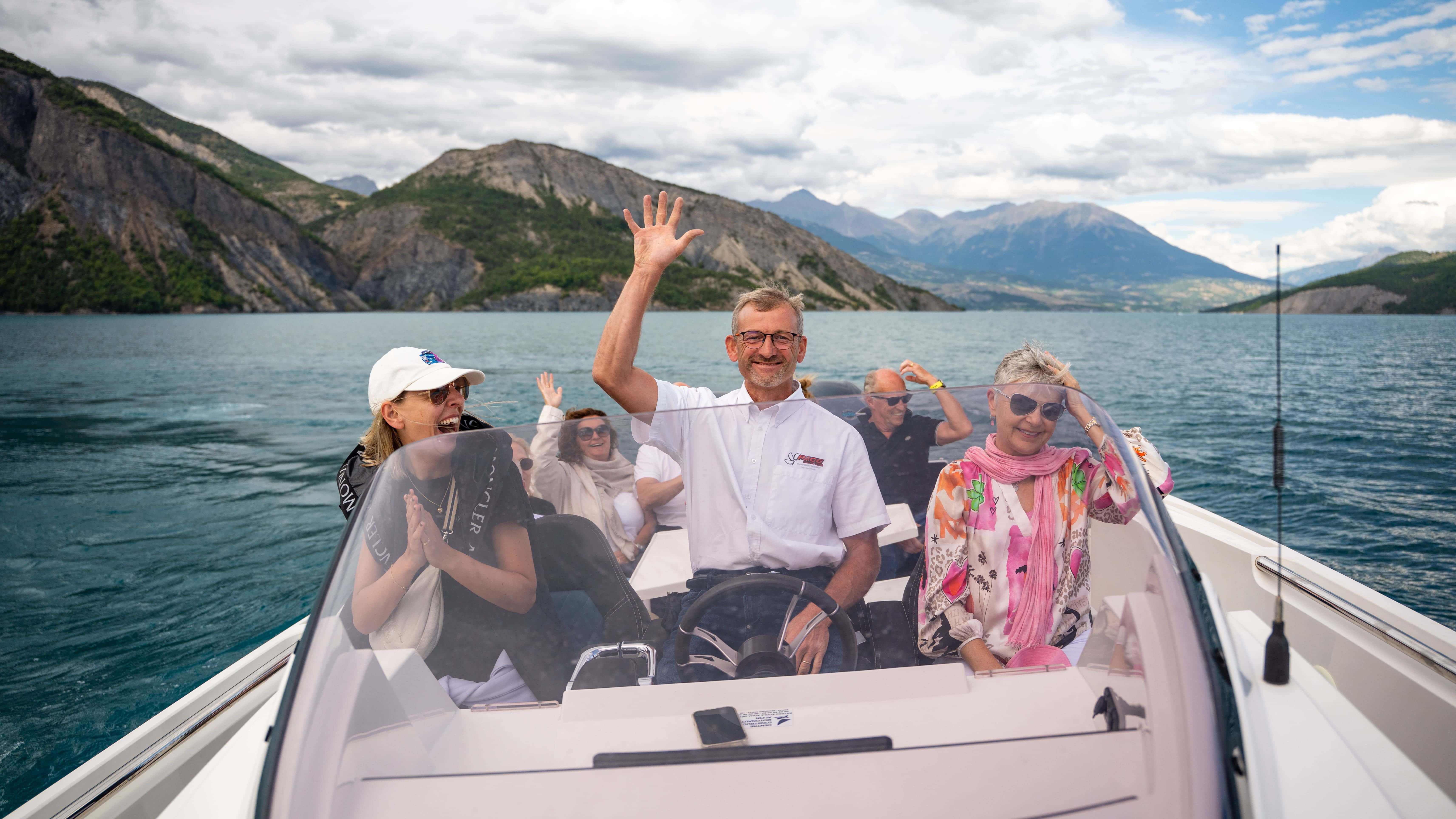 Personen genießen eine Bootsfahrt in malerischer Berglandschaft.