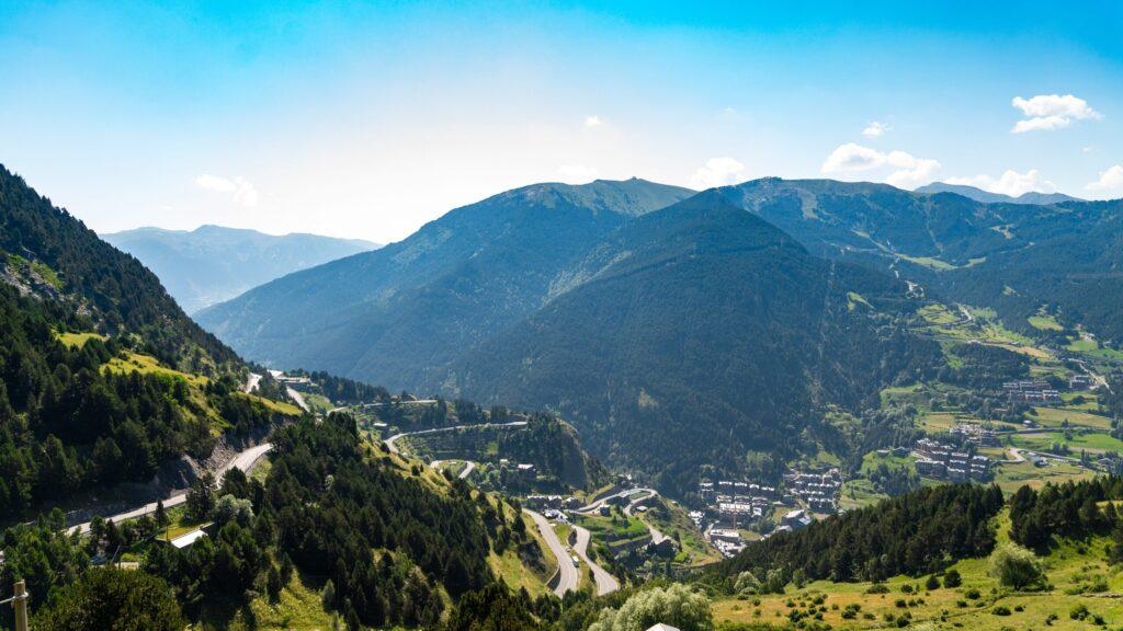Panorama der majestätischen Berge und kurvigen Straßen in der Sonne der Pyrenäen. Idealer Hintergrund für Luxus-Sportwagenabenteuer.