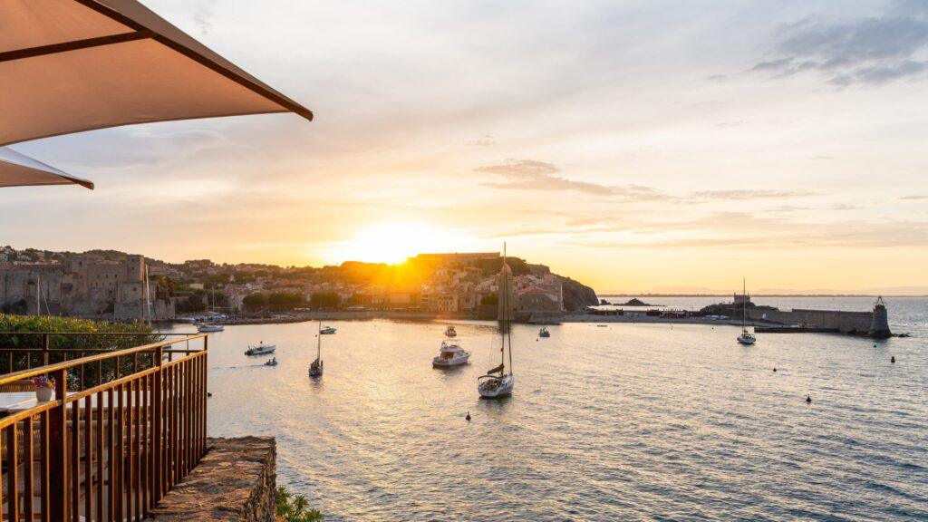 Malerischer Sonnenuntergang über einem mediterranen Hafen bei der Vuelta Pyreneo Tour.