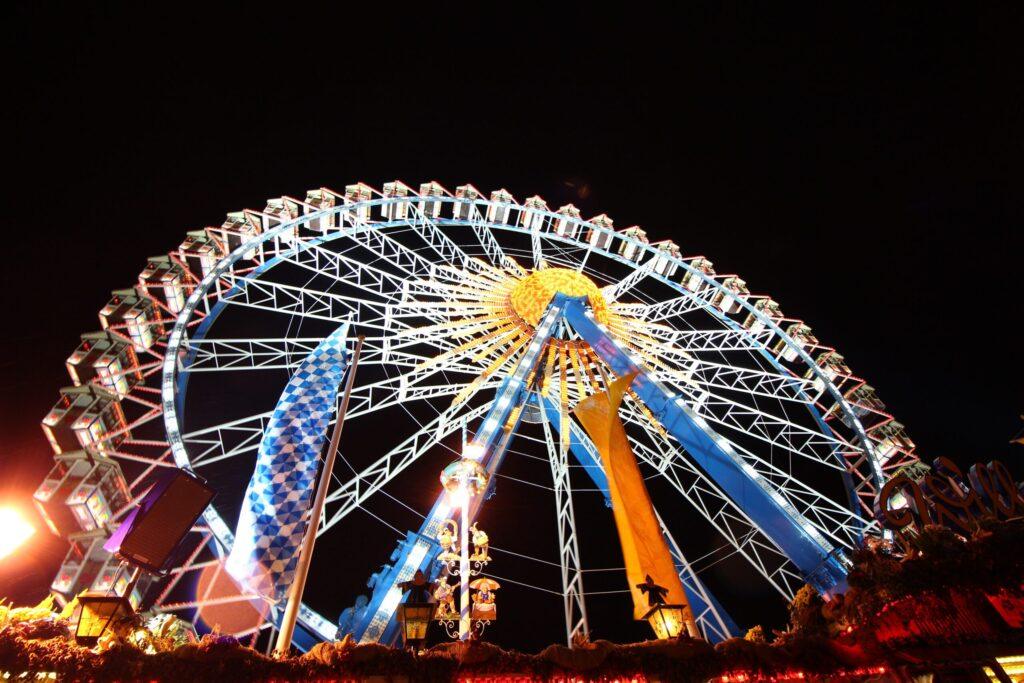 Beleuchtetes Riesenrad auf dem Oktoberfest bei Nacht als exklusives Event-Erlebnis.