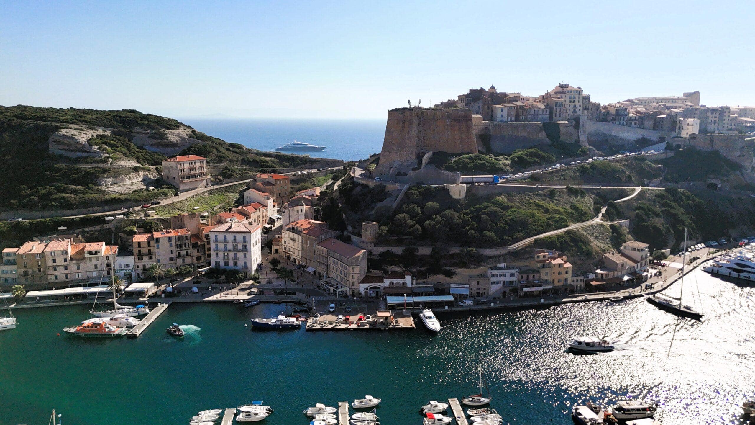 Blick auf die Küstenstadt Bonifacio mit herrlichem blauem Meer, Yachten und historischer Architektur.