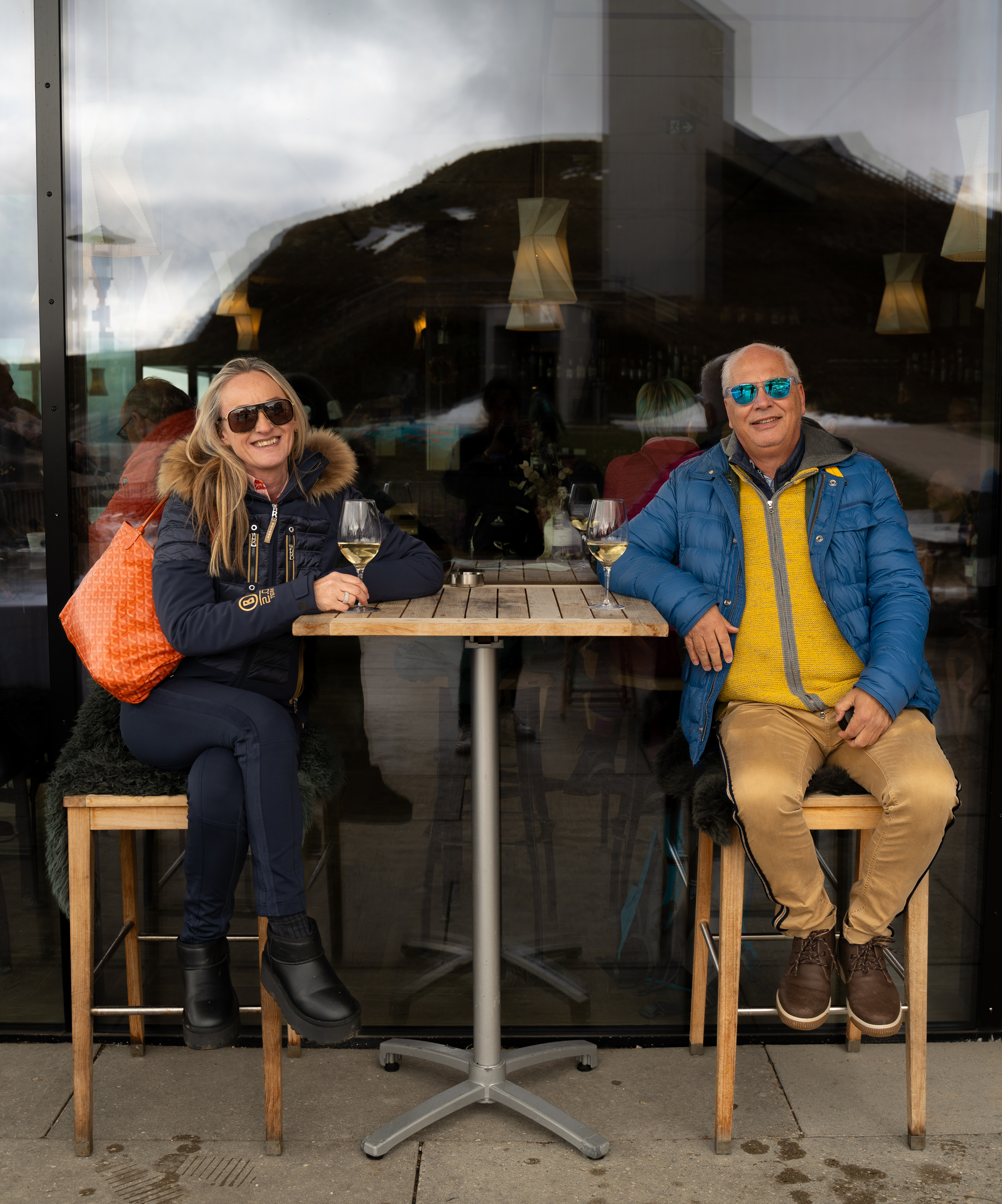 Entspannte Pause mit Weißwein auf der Terrasse während einer Sportwagen Erlebnisreise in den Bergen.