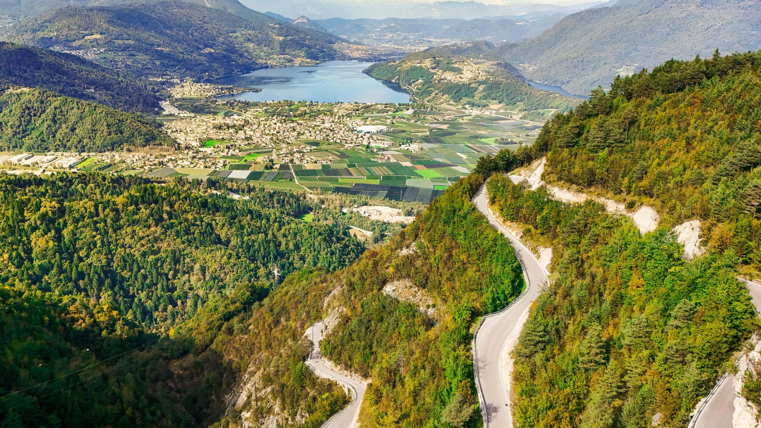 Serpentinenstraße durch malerische Landschaft mit Blick auf einen See in den Dolomiten.