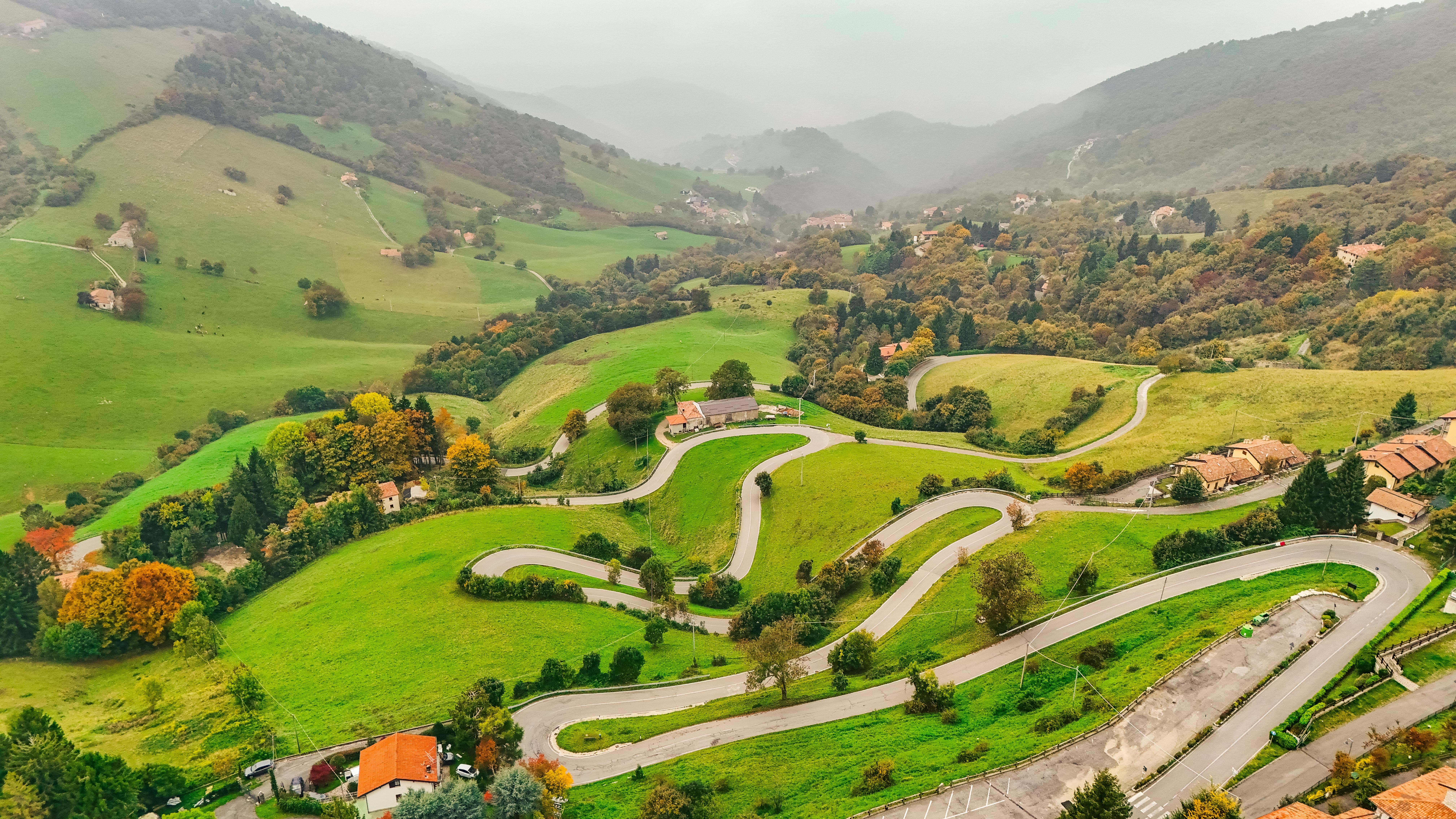 Kurvenreiche Straßen mit atemberaubendem Ausblick auf die grüne Landschaft der Hügel, ideal für Fahrerlebnisse.