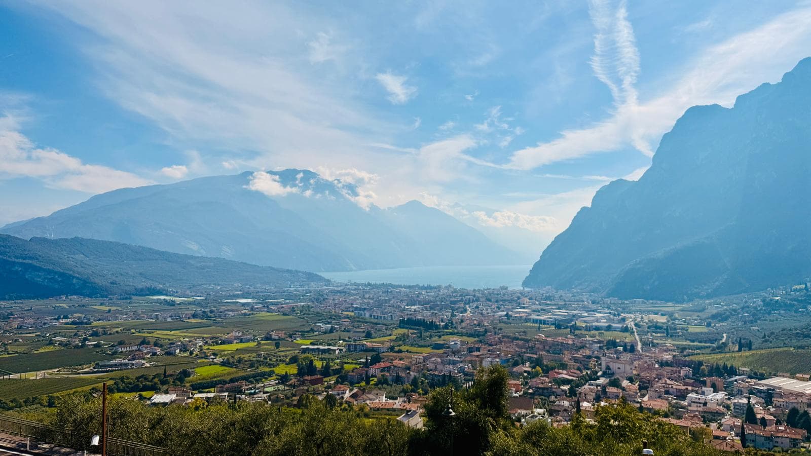 Panorama über den Gardasee mit majestätischen Bergen und üppigen Weinbergen. Ideal für eine Autofahrt durch die Landschaft.