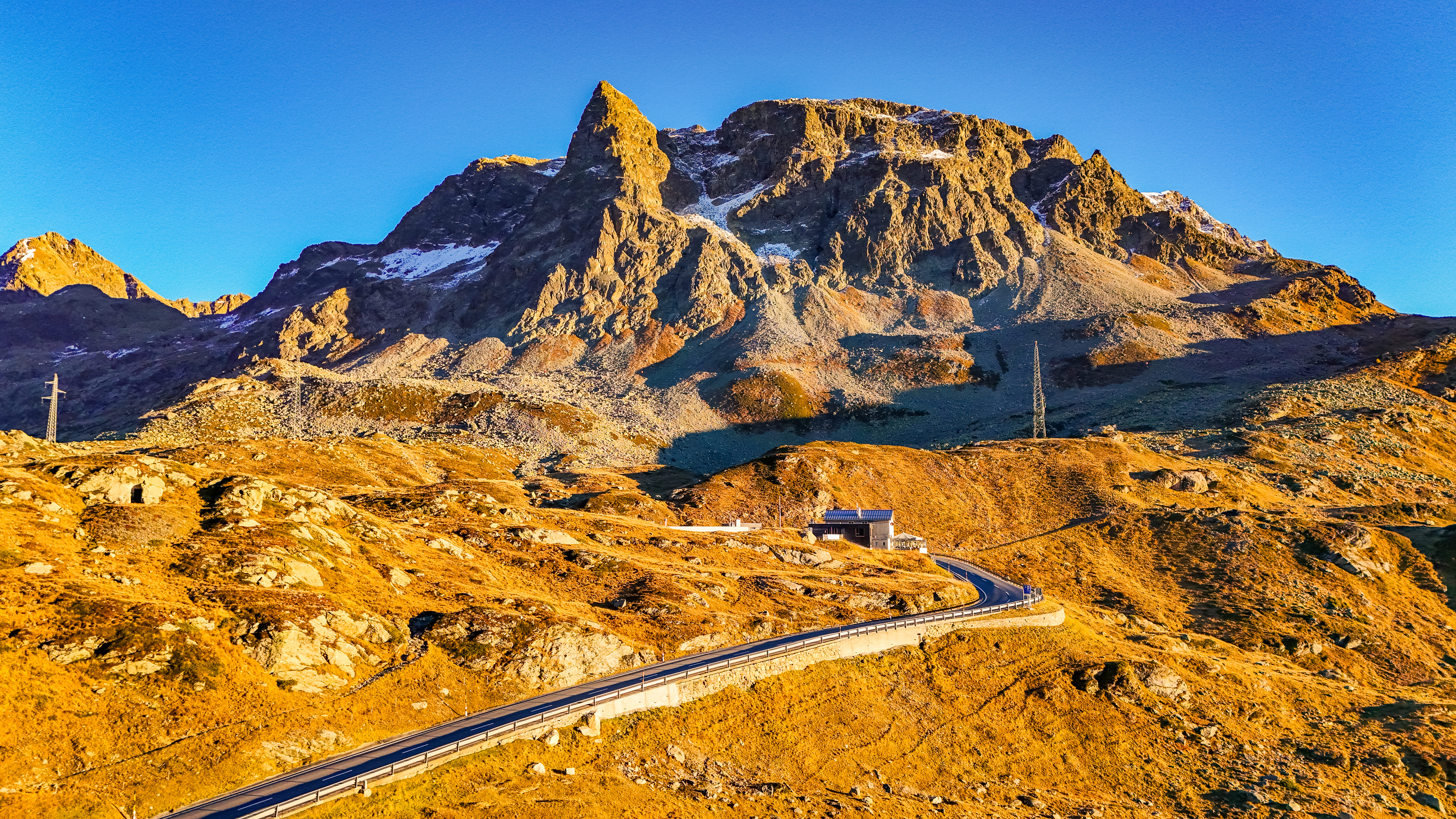 Bergstraße mit atemberaubender Aussicht in den Alpen im Sonnenuntergang.
