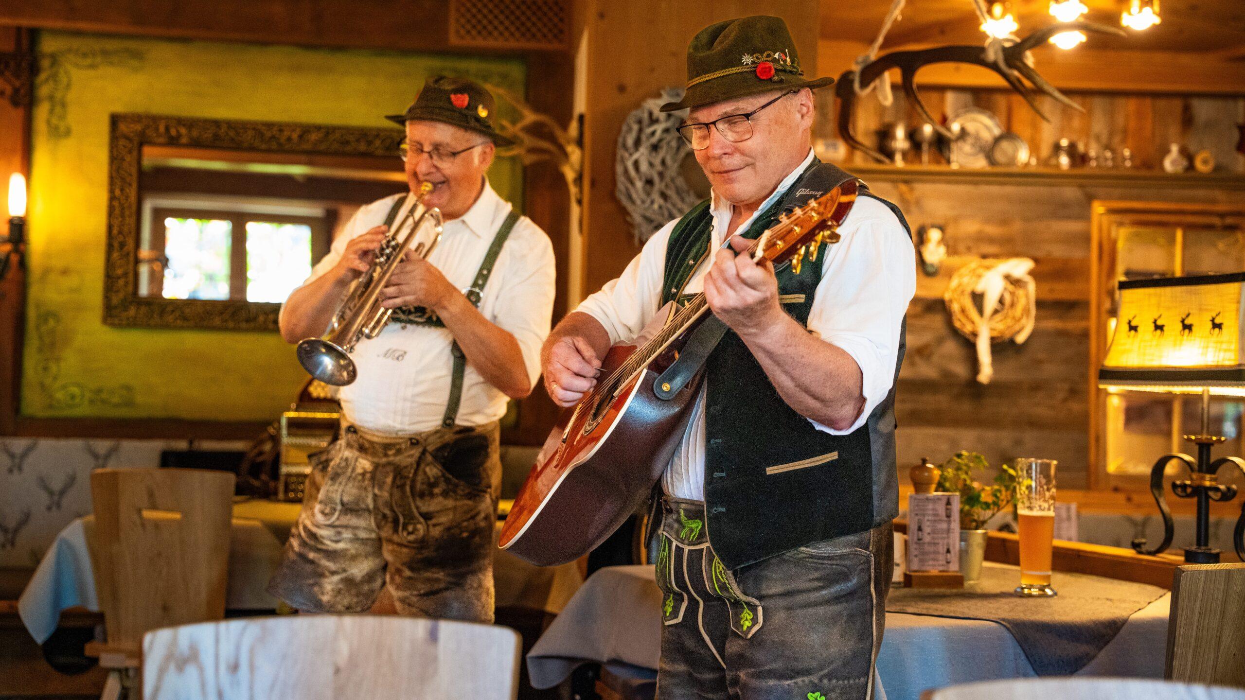 Musiker spielen traditionelle Instrumente in einer gemütlichen bayerischen Gaststube.