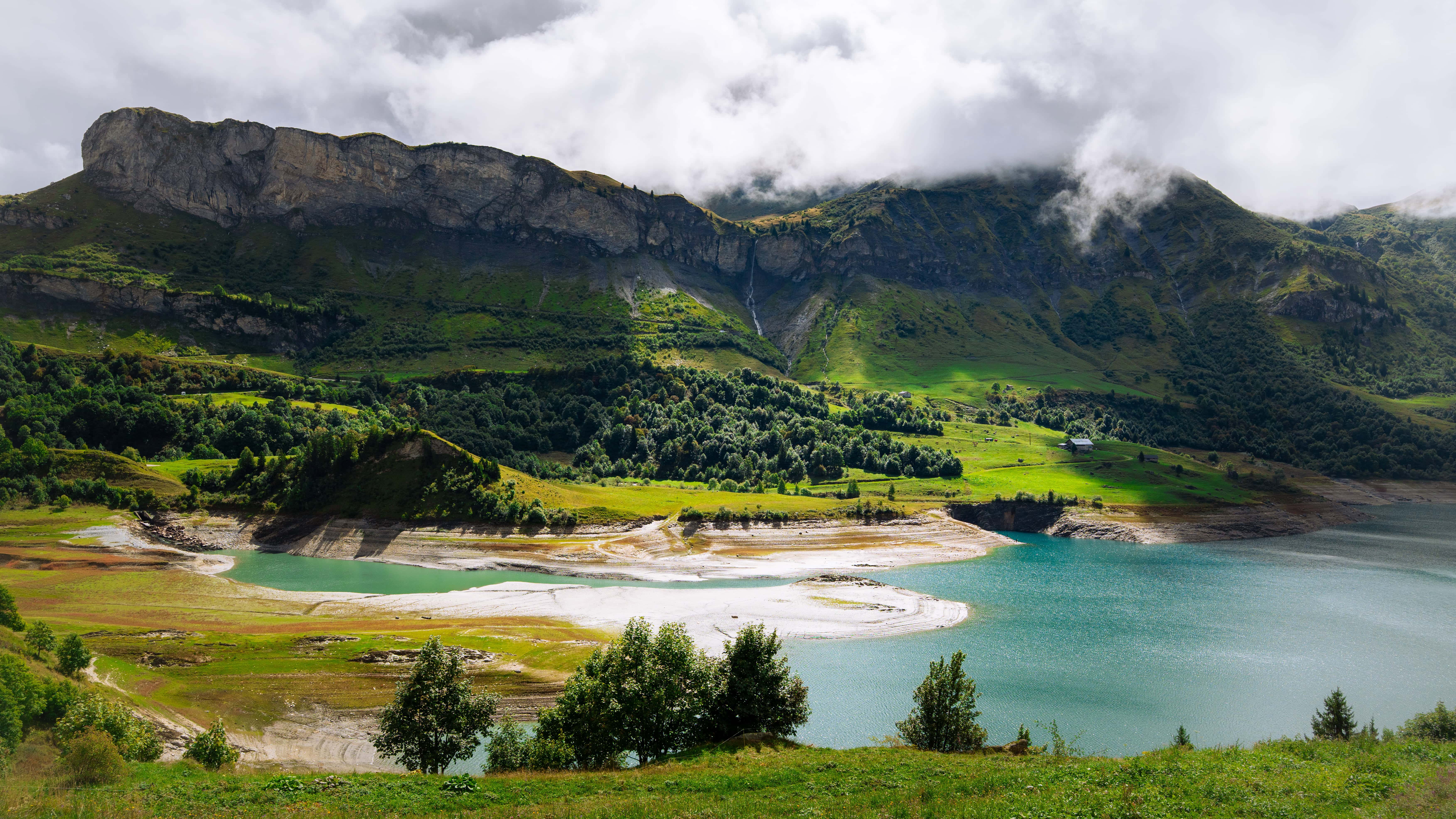 Idyllische Alpenlandschaft mit grünem Bergpanorama und glitzerndem Wasser. Ideal für unvergessliche Fahrerlebnisse.