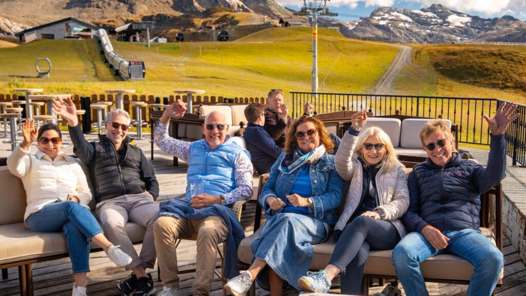 Gruppe von Reisenden genießt entspannte Momente mit Aussicht auf die Alpenlandschaft.