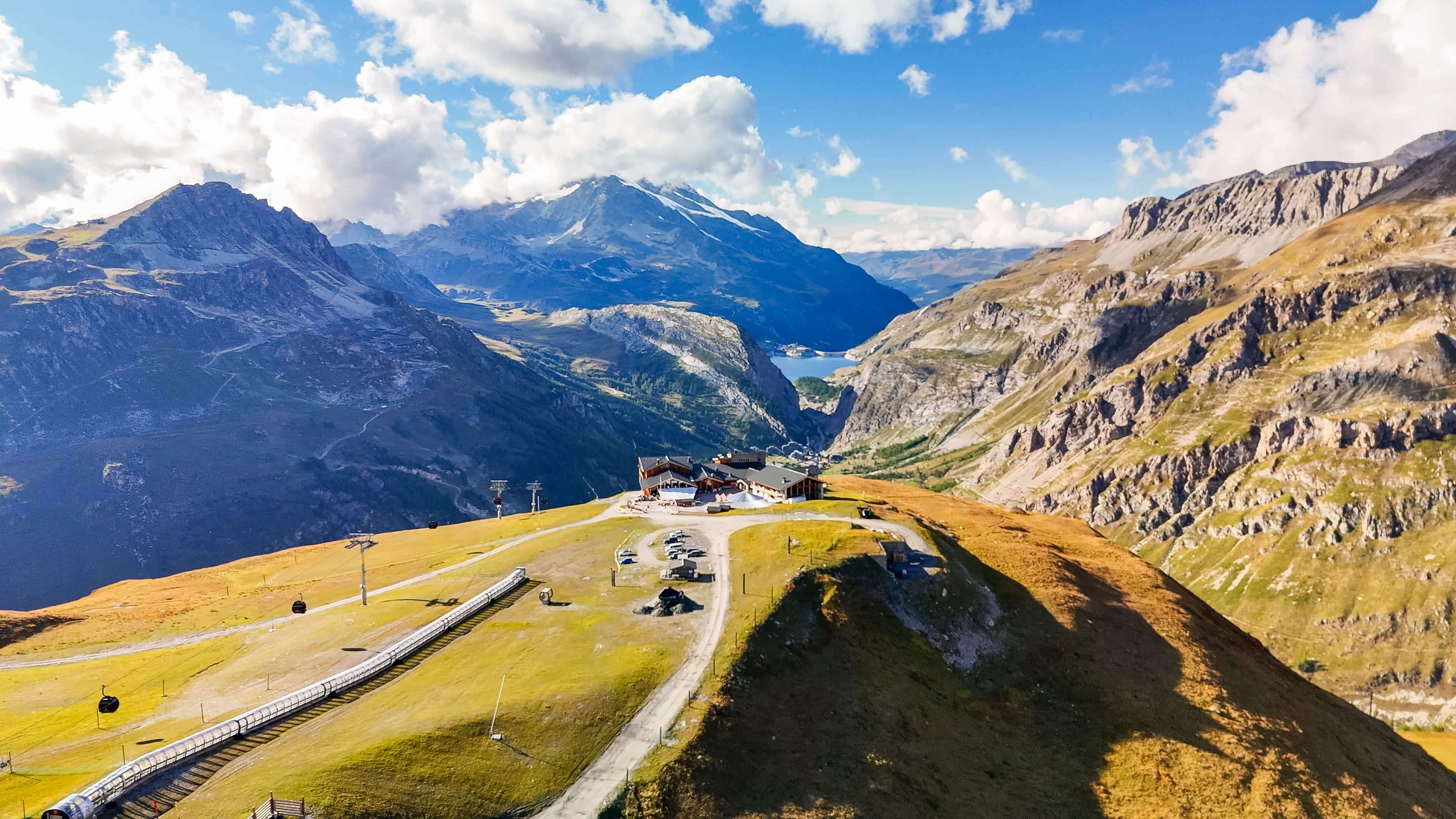 Atemberaubende Berglandschaft der Alpen mit Kabelbahn und luxuriösem Alpenhotel. Perfekt für Sportwagen-Abenteuer.