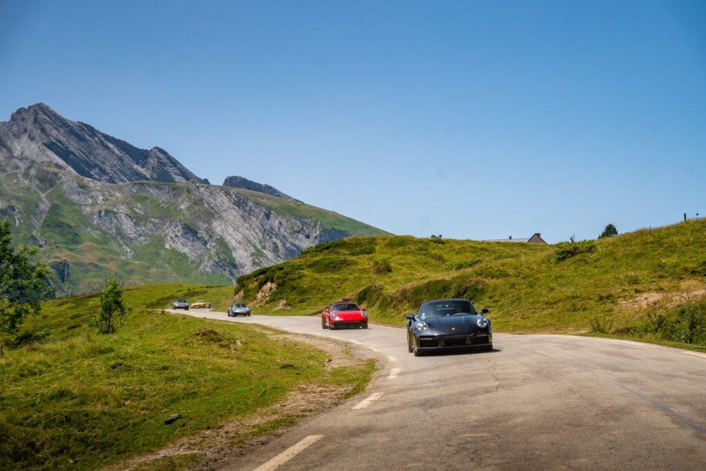 Sportwagen fahren auf kurvigen Straßen in den malerischen Alpen.