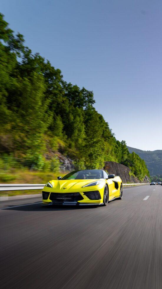 Gelbe Corvette C8 fährt dynamisch auf einer Experten-Tour durch die Berge.