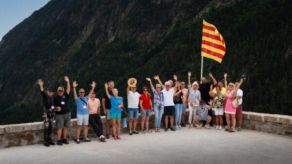 Gruppe von Fahrern posiert vor atemberaubender Bergkulisse, Alpenreise-Abenteuer.