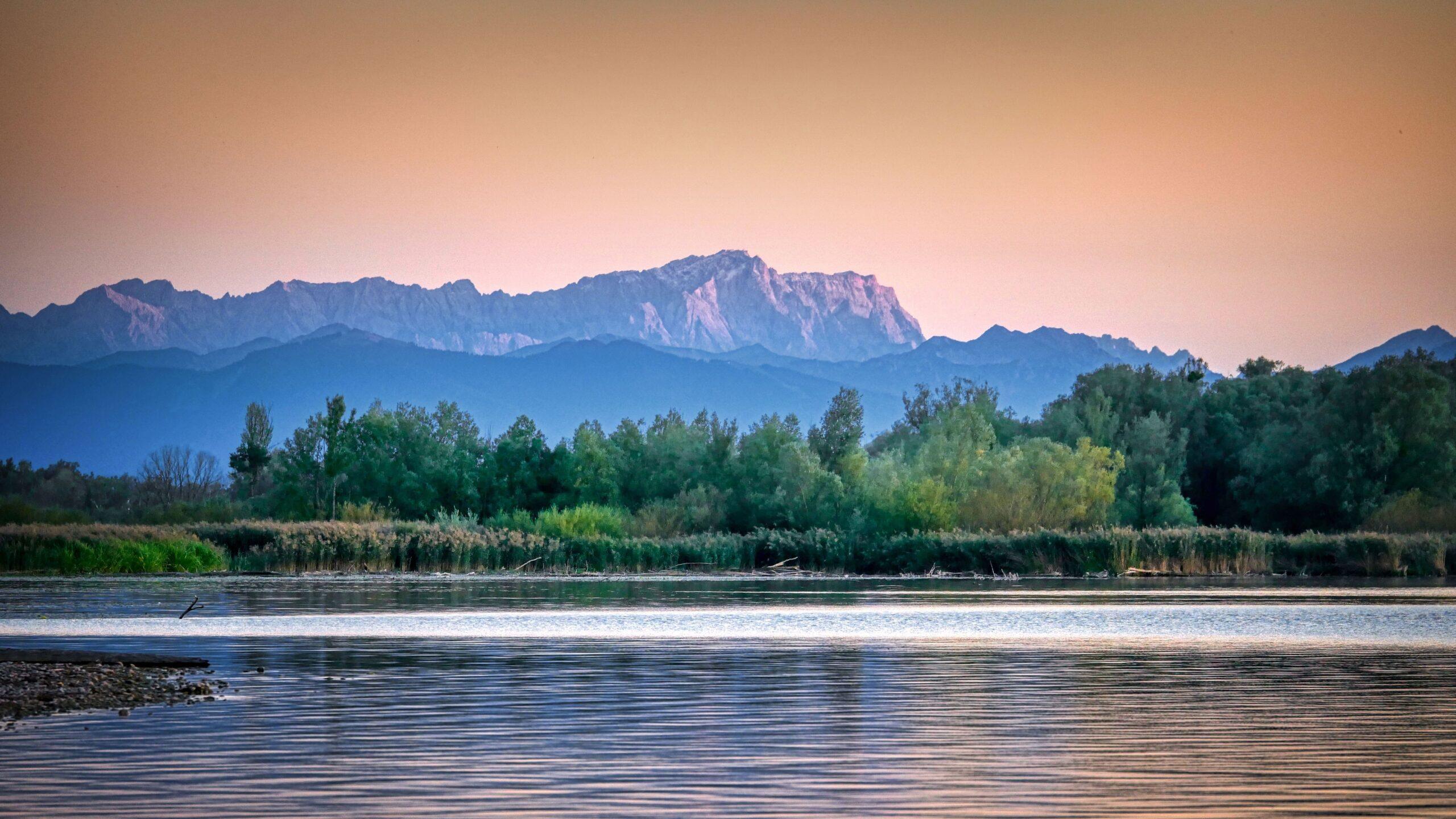 Sonnenuntergang über den Dolomiten spiegelt sich im ruhigen Wasser eines Sees.