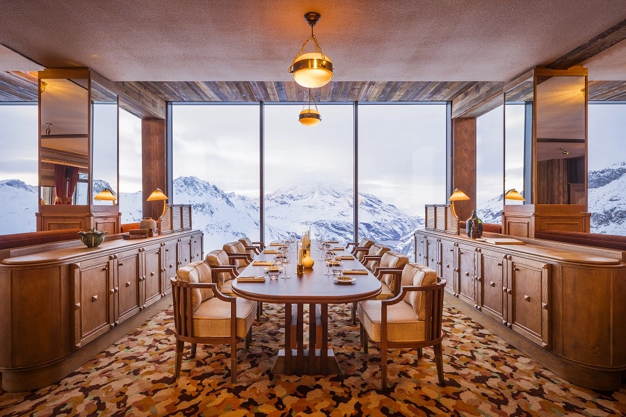 Elegantes Restaurant mit Panoramablick auf verschneite Berge in den Alpen.