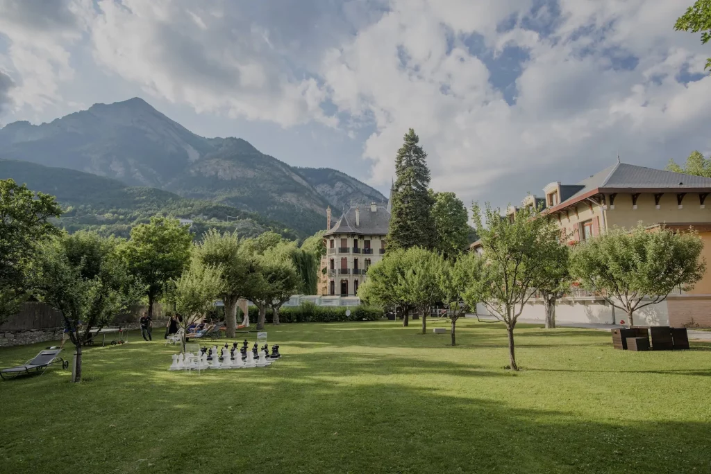 Grüner Hotelgarten mit Bergblick und Schachspiel in den Alpen.