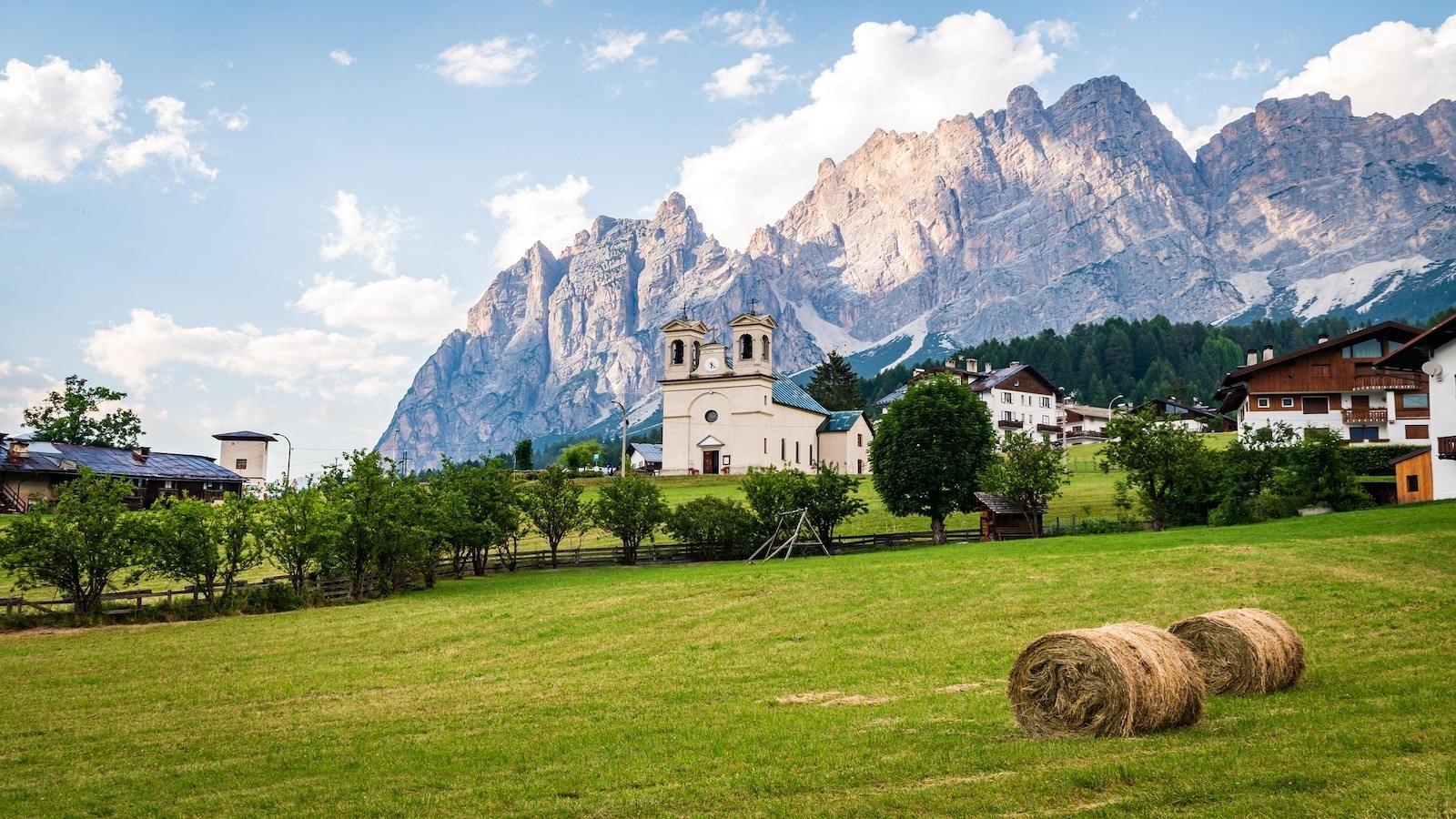 Kirche und malerisches Bergpanorama in den Dolomiten bei Sonnenschein.